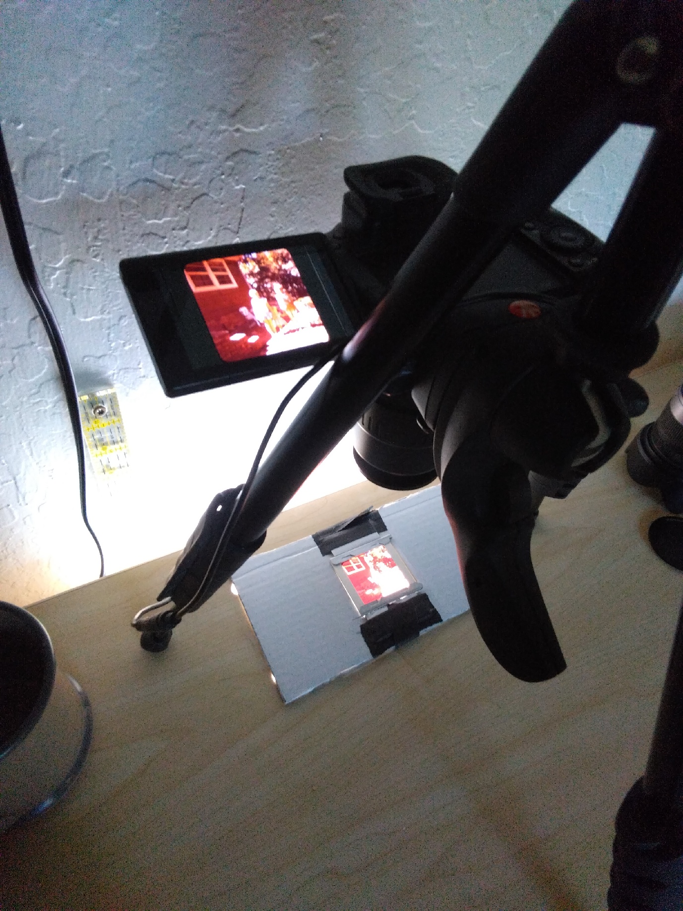 A camera aimed at a lightbox built into a desk with a slide on it